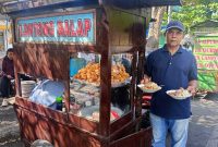 Frengky menunjukkan lontong balap jualannya yang digemari warga. Lapaknya, berada di depan GOR jalan Gus Dur, Desa Candimulyo, Kecamatan/ Kabupaten Jombang.