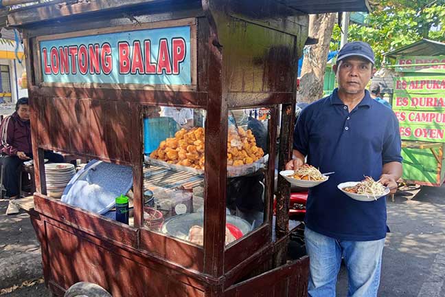 Frengky menunjukkan lontong balap jualannya yang digemari warga. Lapaknya, berada di depan GOR jalan Gus Dur, Desa Candimulyo, Kecamatan/ Kabupaten Jombang.