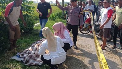 petugas melakukan pemeriksaan pada tubuh korban yang meninggal di pinggir jalan banjarsari jombang